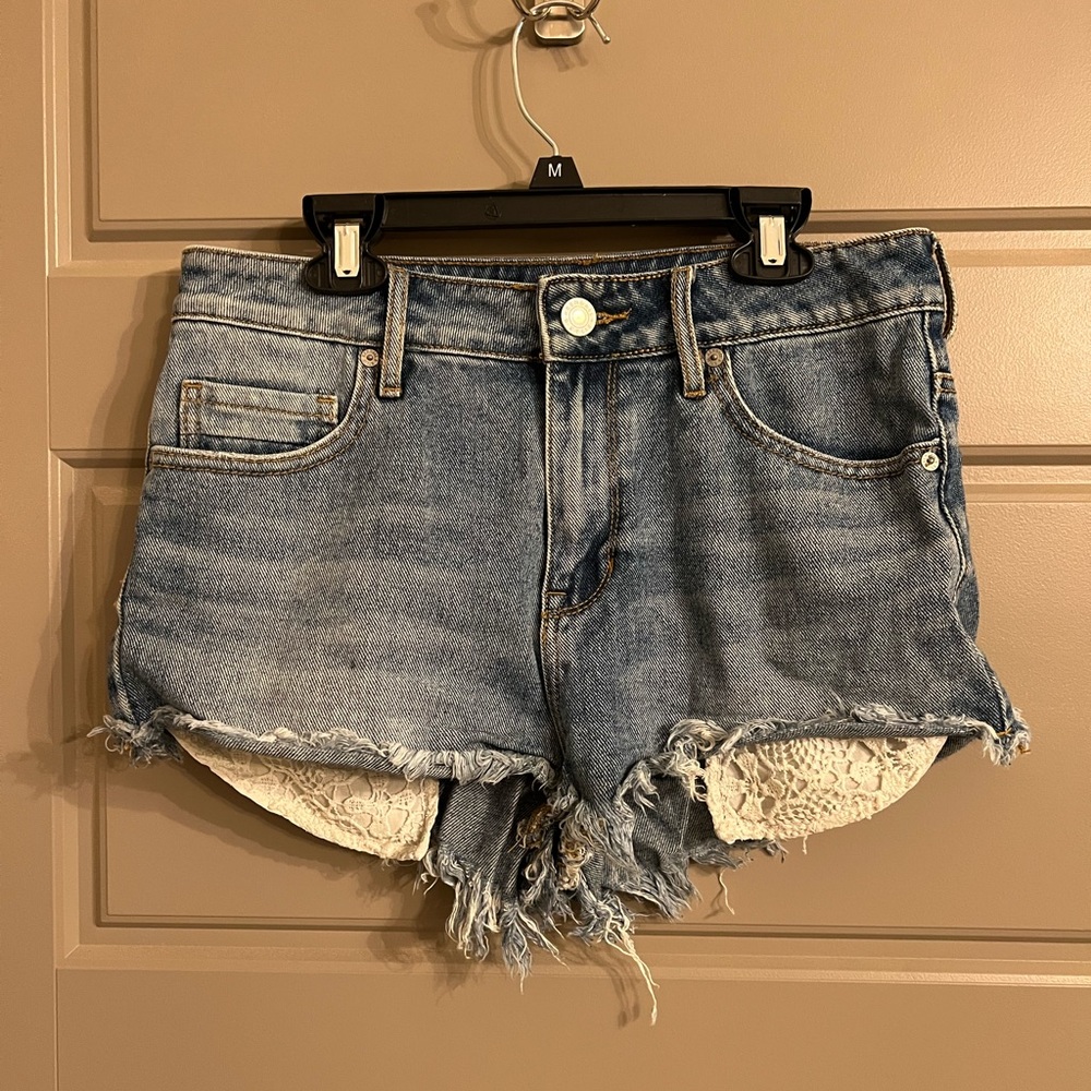 Light wash jean shorts with floral pattern pockets